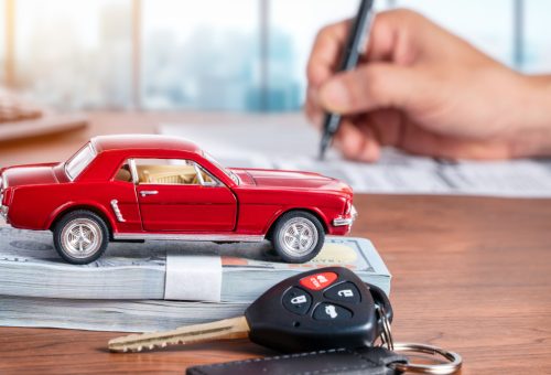 Car loan or buying a new car concept. Red car on dollar banknote